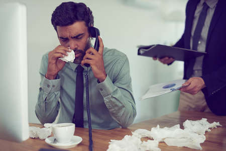 He could do with a time-out from work. Cropped shot of a businessman suffering with allergies in an office.の写真素材