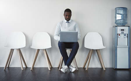 Success is what you go for. Studio shot of a businessman waiting in line against a white background.の写真素材
