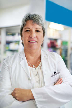 Addressing your health concerns with professionalism and expertise. Portrait of a confident mature woman working in a pharmacy.の写真素材