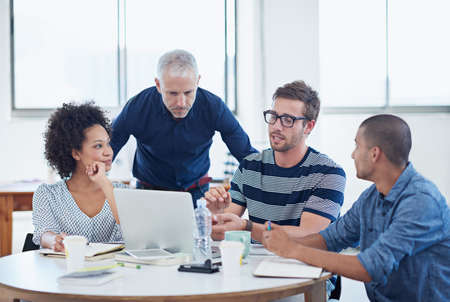 An office full of great ideas. Shot of a group of designers at work in an office.の写真素材