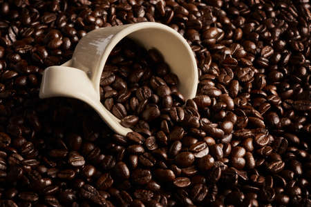 Every bean is packed with energy. Closeup shot of a cup on a pile of coffee beans.