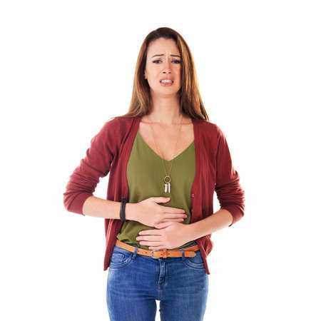I dont feel too good. Studio shot of a young woman holding her stomach and feeling unwell isolated...