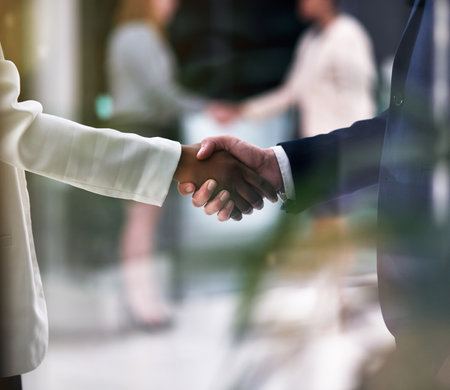 Introductions are in order. Shot of businesspeople shaking hands in an office.の写真素材