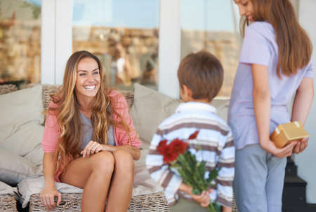For the best mom ever. Shot of a mother and her two children holding gifts for mothers day.の写真素材