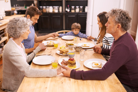 Bless this food to our bodies. Cropped shot of a family saying grace before eating breakfast.