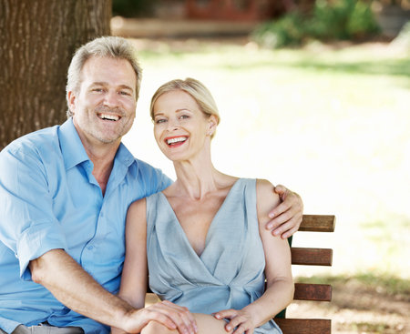 Loving and laughing together. Loving mature couple spending time together while outdoors in a park.の写真素材