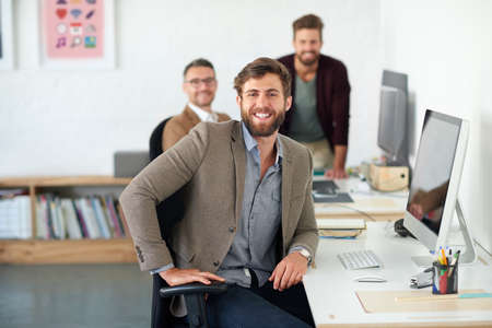 Confident and creative. Portrait of a handsome businessman working in his office.の写真素材