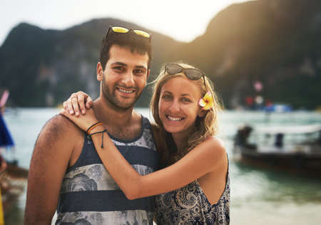 In love on the beach. Portrait of a young couple enjoying a day at the beach together.の写真素材