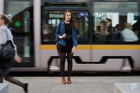 I have arrived. Portrait of an attractive young female photographer standing on the subway with a...