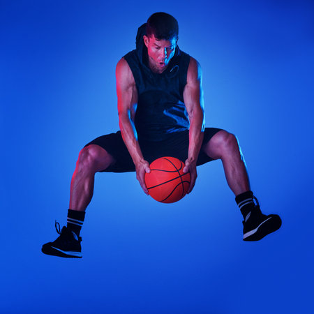 I play to win. Blue filtered shot of a sportsman playing basketball in the studio.
