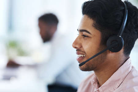 Handling caller inquiries like a pro. Shot of a young call centre agent working in an office.