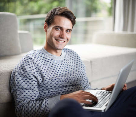 Positive about technology. Portrait of a handsome young man using his laptop.