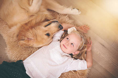Were in this together, kid. An adorable little girl with her dog at home.の写真素材