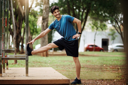 See I can touch my toes. Shot of a sporty young man doing stretching techniques while exercising...