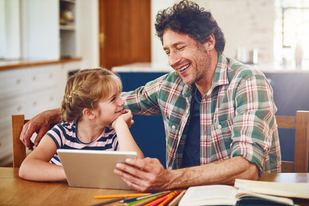 Youre really good at explaining stuff hey Dad. Cropped shot of a father helping his daughter complete her homework on a digital tablet.の写真素材