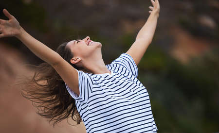 Life is a gift waiting for you to receive it. Shot of a young woman celebrating while out in nature.