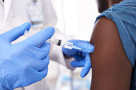 Get one before flu season. Closeup shot of a male patient receiving an injection from a doctor.の写真素材