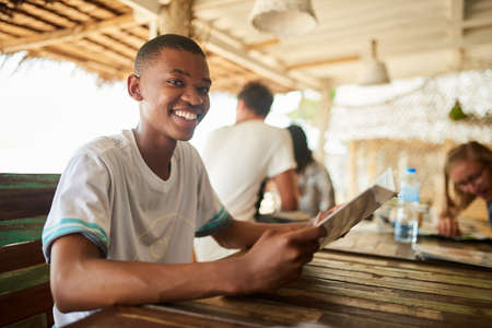 Whats on the menu. Portrait of a young man reading a menu in a restaurant.の写真素材