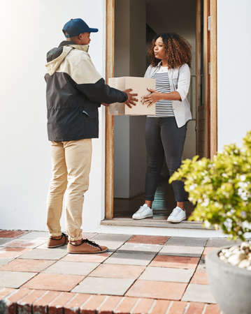 Our aim is to get it to you with speed. Shot of a courier making a delivery to a customer at her...