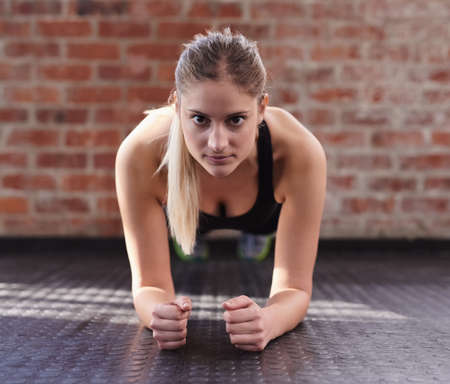 Time to make that core pop. Shot of a woman doing bodyweight exercises at the gym.