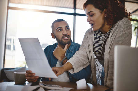 Ensure you delve into your budget with a solid plan. Shot of a young couple planning their budget...