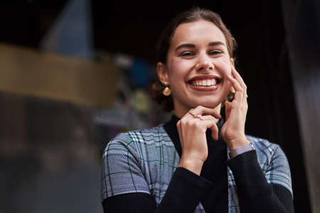 Her smile says it all. Cropped shot of a beautiful young woman out in the city.