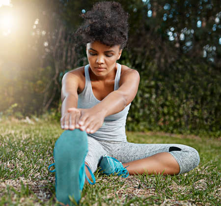 Stretch your limits if you can. Shot of a young woman stretching outside before her run.