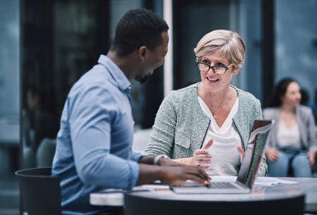 The team that has what it takes. Shot of a businessman and businesswoman using a laptop during a meeting at a convention centre.の写真素材
