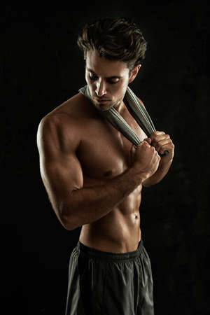 Built his body to perfection. Sexy young man with his shirt off - Isolated on white.の写真素材