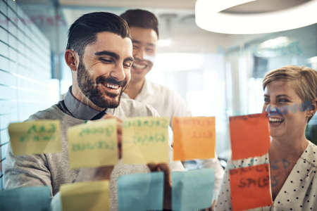 Success is theirs with these great ideas. Shot of businesspeople brainstorming with sticky notes on...
