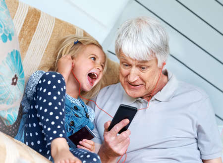Listen to this. Shot of an adorable little girl listening to music from a cellphone with her...