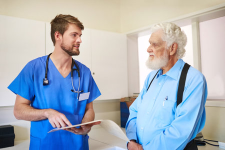 Well get to the bottom of your pain. Shot of a young doctor and his senior patient discussing his medical records together.の写真素材
