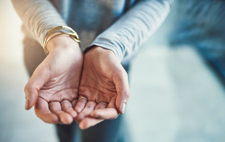 Asking for some aid. Closeup shot of hands cupped together.の写真素材