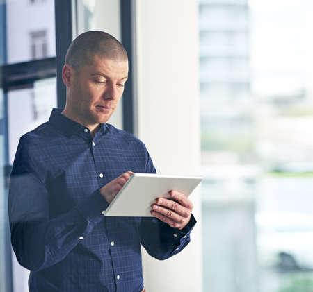Smarter business research supported by smart technology. Shot of a businessman using a digital...