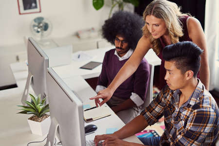 Laying out their top designs. Shot of a group of designers working on computers in an office.