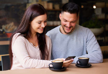 Lets use this code for a discount. Shot of a woman showing showing her boyfriend something on her...