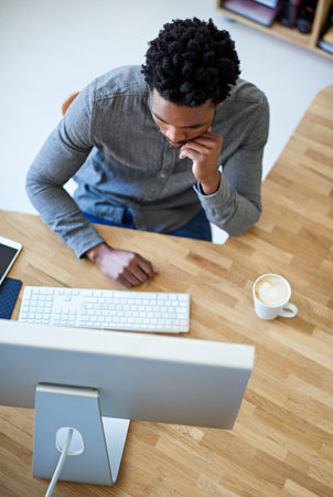 Go getter in action. High angle shot of a young male designer at his desk.