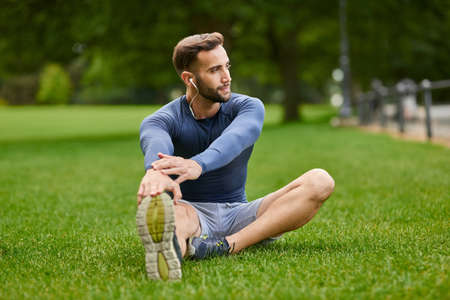 He never misses a warmup. Full length shot of a handsome young male runner warming up before his workout.の写真素材