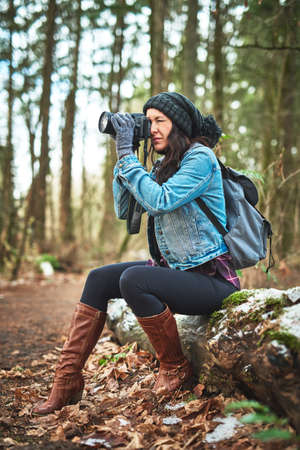 I have to take photos while Im travelling. Shot of a young woman taking a picture in the outdoors.の写真素材