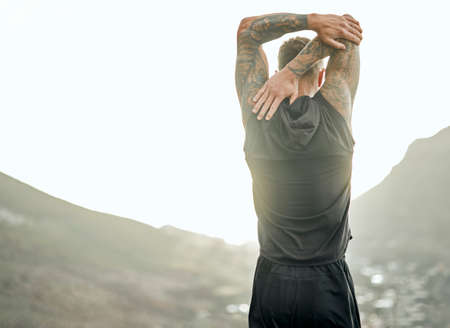 Stretching those muscles. Shot of an unrecognizable man stretching before a run.