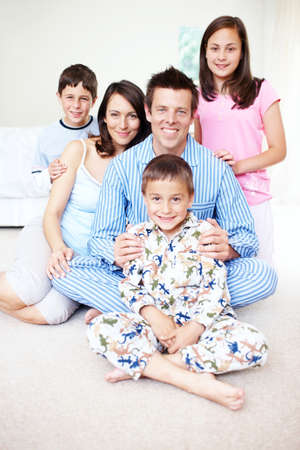 Early risers on a saturday morning. Portrait of a cute little boy with his family sitting behind him...