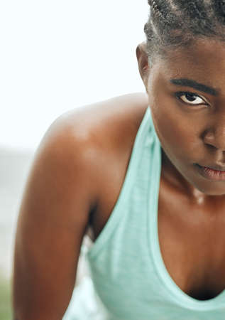 Stay focused on your goal. Shot of a young woman resting while running.の写真素材