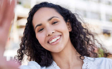 Your smile is 50 of your selfie. Portrait of a happy young woman taking selfies against an urban...