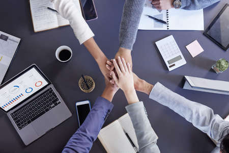 Youve got my vote. Shot of a group of unrecognizable businesspeople stacking their hands at work.の写真素材