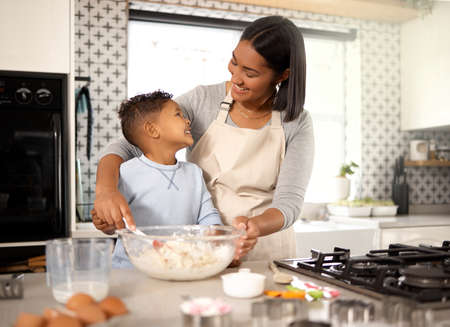Mom, can I have a taste. Shot of an adorable little boy baking with his mom at home.の写真素材