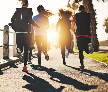 Having someone to motivate you makes all the difference. Rearview shot of a fitness group out...