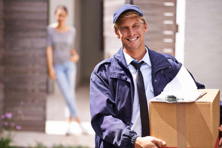 It always arrives on time. Shot of a courier making a delivery to a smiling customer.