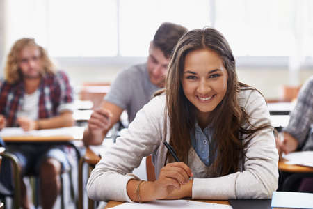 Bright young minds of tomorrow. Positive young students in a college classroom.