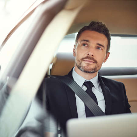 Thinking about the day ahead. Cropped shot of a businessman in the backseat of a car.