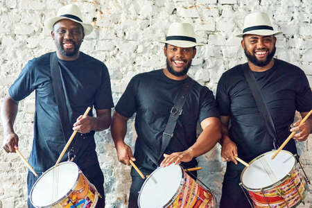 Listen to our Samba sounds. Cropped portrait of a group of handsome young male drummers playing at...